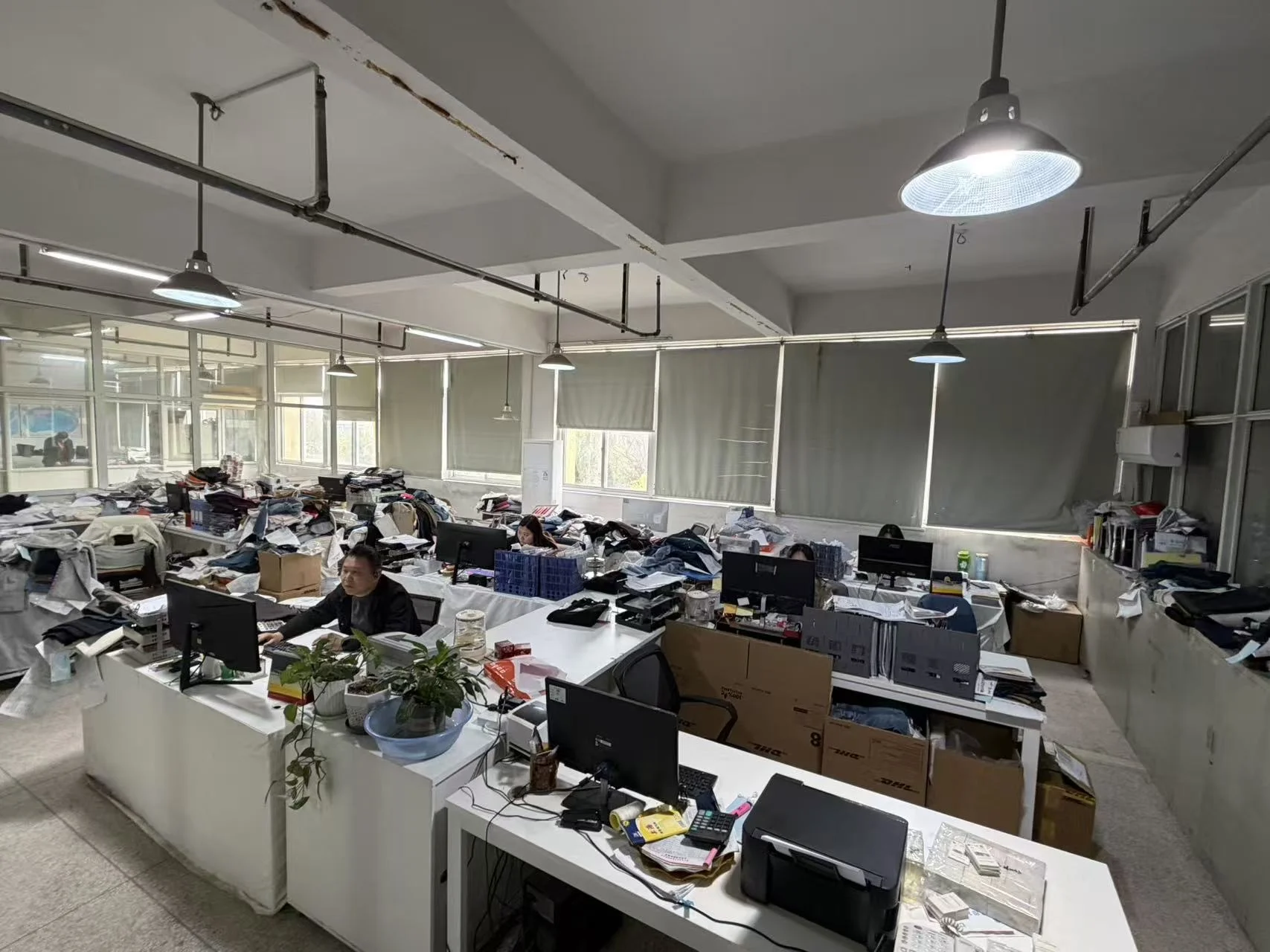 设计台前展开的纸样与面料，手部指示裁剪与对位细节